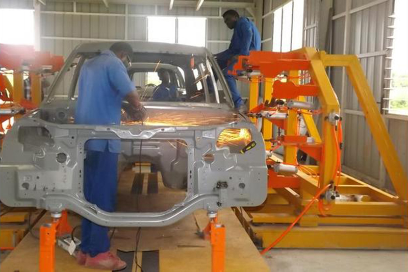 This shows the state of Kantanka’s factory, where we see a complicated stamping that I can not believe was produced in Ghana itself. I also can not explain why the worker is taking a grinder to the firewall. Photo via Africarm.org